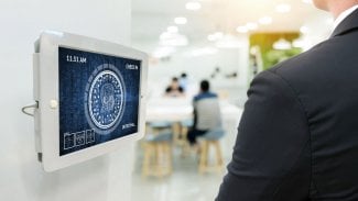 Technologie systémů strojového učení, přesná biometrická technologie rozpoznávání obličeje a koncept umělé inteligence. Zaměstnanci se přihlašují v kanceláři pomocí digitálního displeje s funkcí rozpoznávání obličeje.