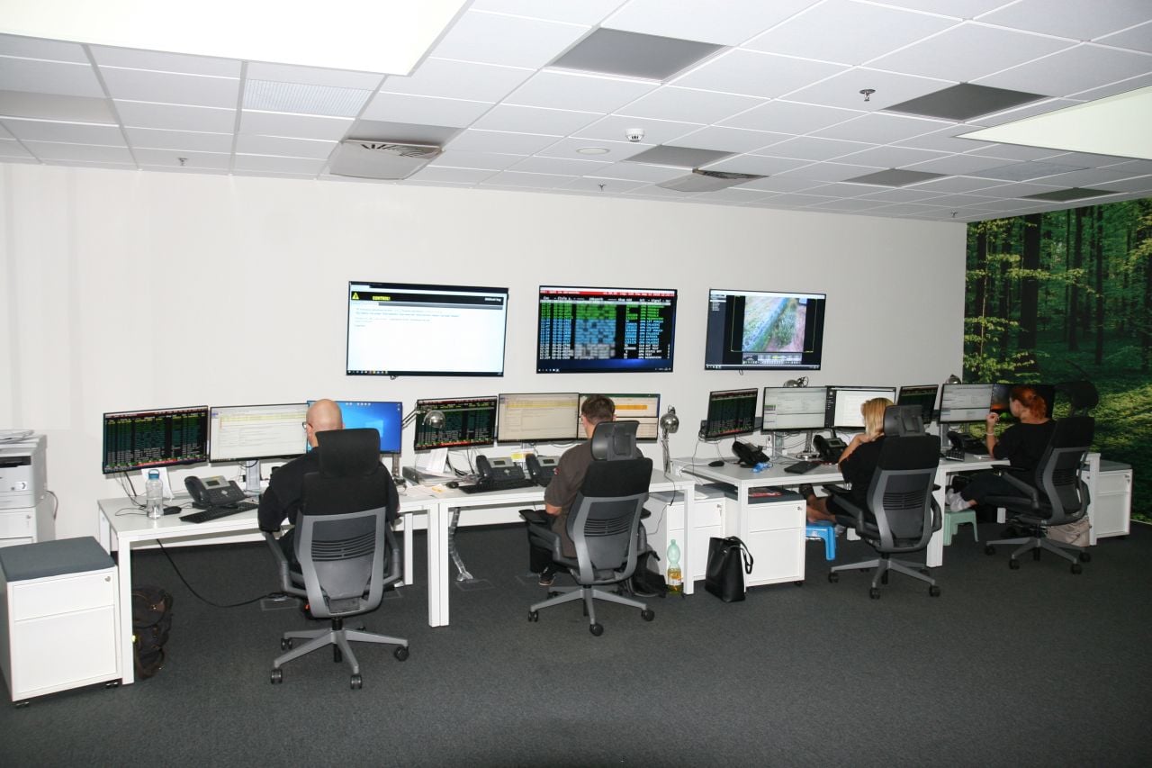 Na samotném SOC centru je zajímavé, že zde nenalezneme jediné okno, vyžadují to bezpečnostní předpisy. Stěny tak oživují alespoň tapety s lesním motivem.