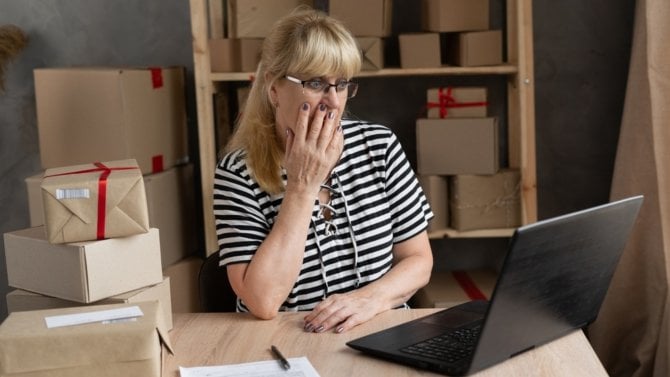 Žena spravující internetový obchod je překvapena tím, co vidí na počítači