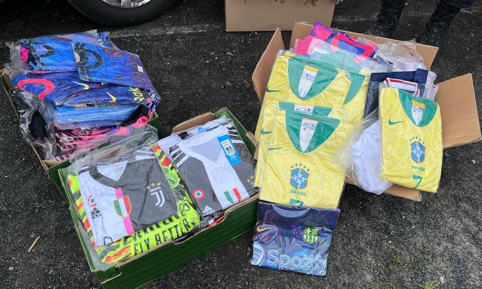 Fotky zaznamenávají kontrolu celníků na bleším trhu, kde odhalili prodejce padělků sportovních dresů