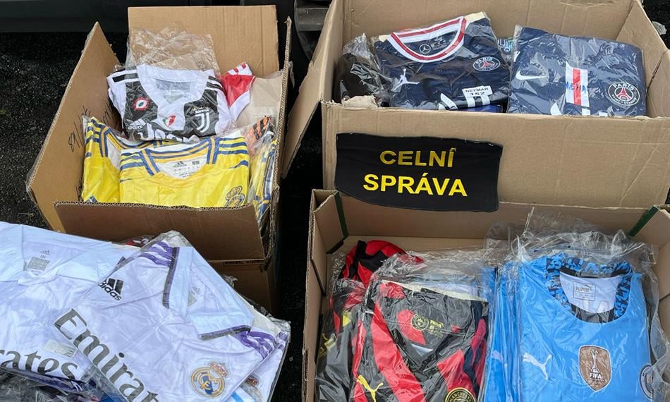 Fotky zaznamenávají kontrolu celníků na bleším trhu, kde odhalili prodejce padělků sportovních dresů