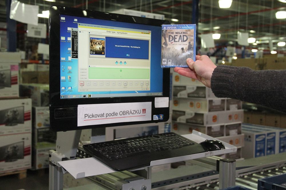 Picker v ní musí najít požadované zboží podle obrázku a popisku. A vložit jej do objednávkové přepravky.