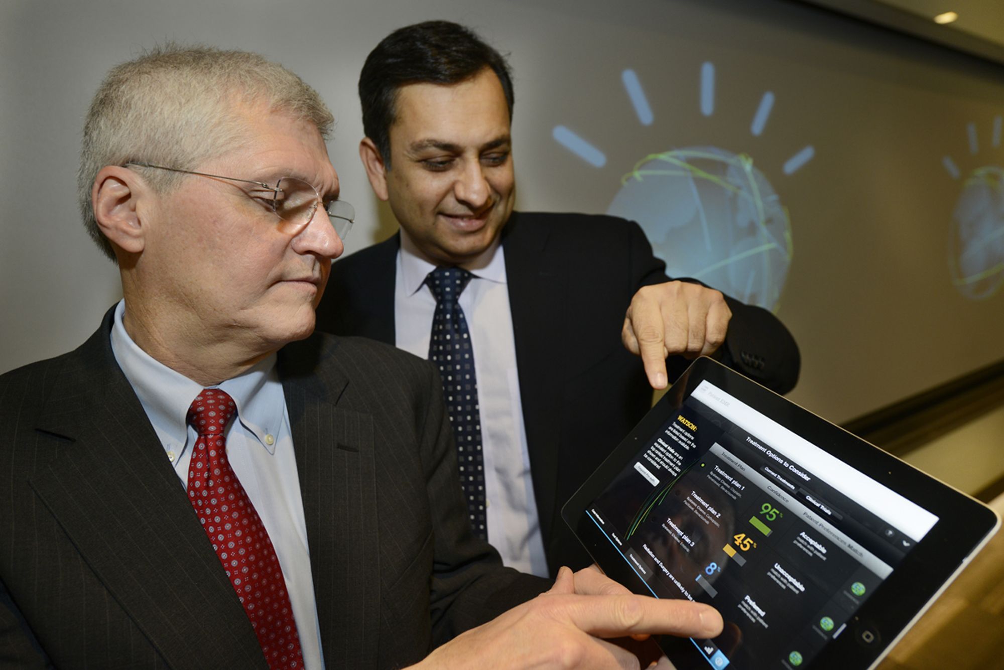 Manoj Saxena, generální ředitel pro IBM Watson Solutions (vpravo) a Mark Kris, vedoucí lékař hrudní onkologie z Memorial Sloan-Kettering Cancer Center, ukazují aplikaci, která dokáže na základě vstupních informací o pacientovi navrhnout nejefektivnější způsob léčby.