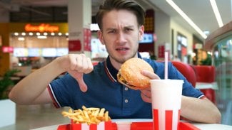 Muž odmítající nezdravé jídlo z fast foodu