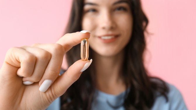 Žena s vitamínem v želatinové kapsli