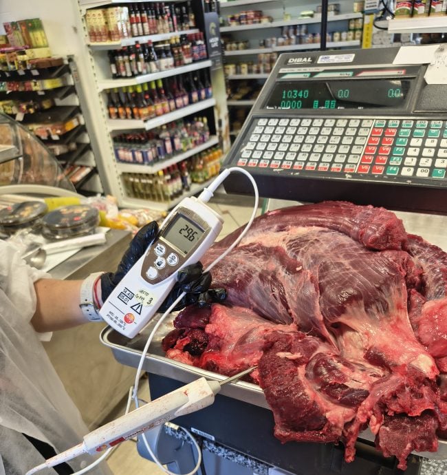 Na obrázku je maso položené na váze. Do něj je aplikován teploměr, který měří teplotu