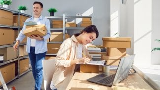 Muž s ženou ve skladu e-shopu chystající balíčky