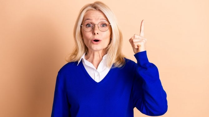 Elegantní starší žena s varovně zdviženým ukazováčkem