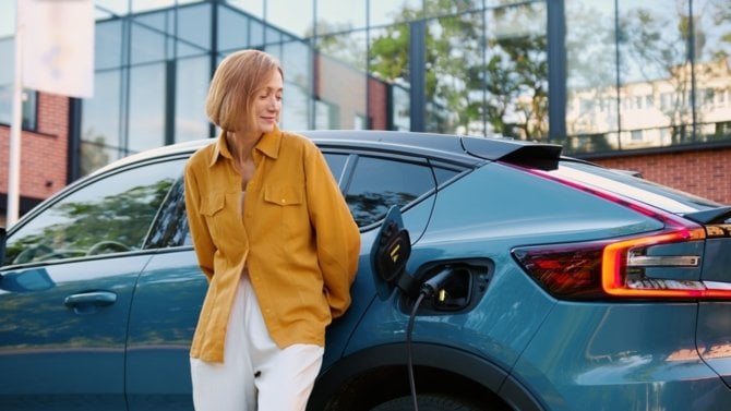 Žena u svého elektromobilu čeká, až se nabije