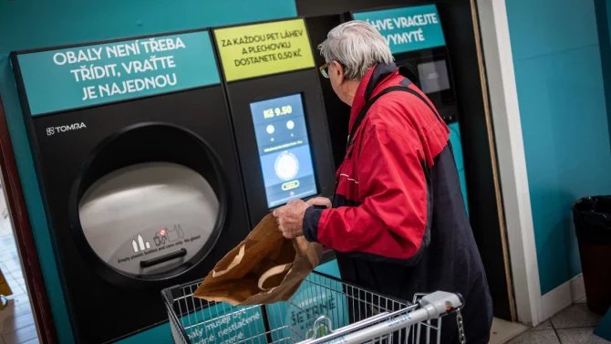 Muž u automatu na vracení PET lahví a plechovek
