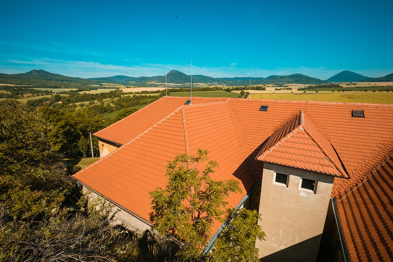 Zámek Skalka v obci Vlastislav na Litoměřicku. Místo dvou krajních jímacích tyčí hromosvodů jsou nainstalovány antény a také bylo vybouráno a ze dřeva vystrojeno okno, tzv. volské oko.