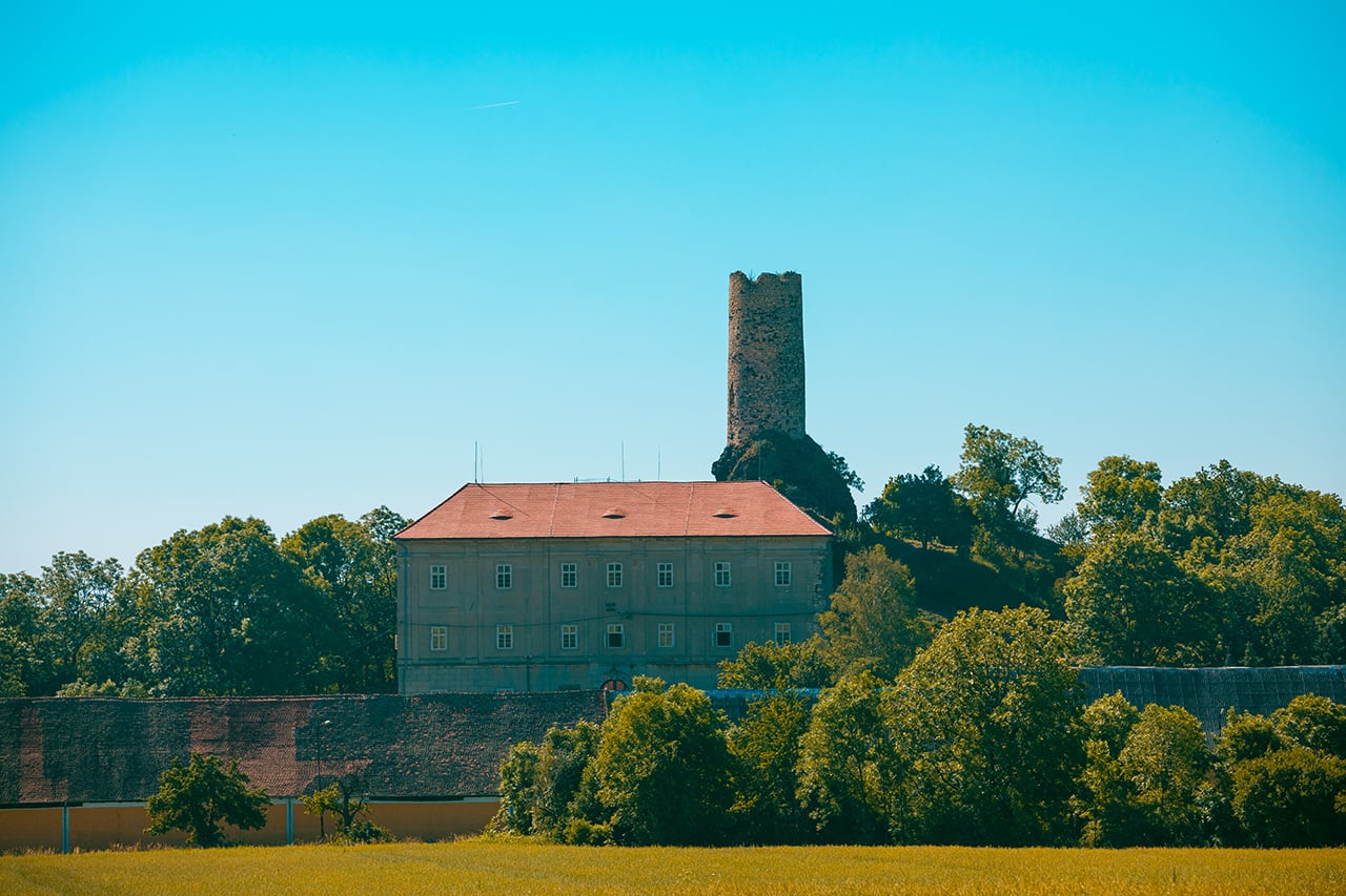 Zámek Skalka v obci Vlastislav na Litoměřicku. Místo dvou krajních jímacích tyčí hromosvodů jsou nainstalovány antény a také bylo vybouráno a ze dřeva vystrojeno okno, tzv. volské oko.
