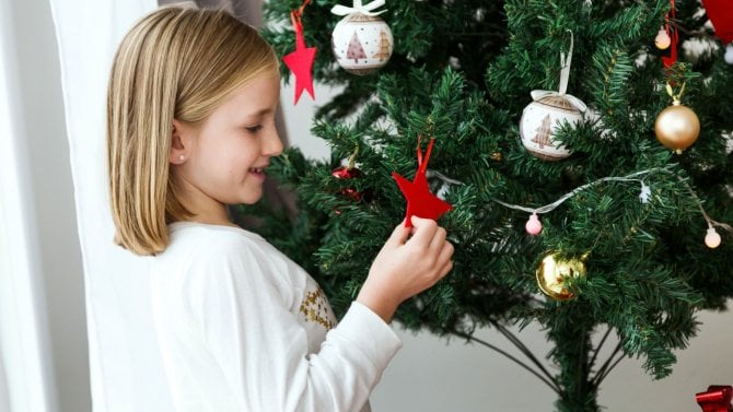 Holčička si hraje s textilní vánoční ozdobou