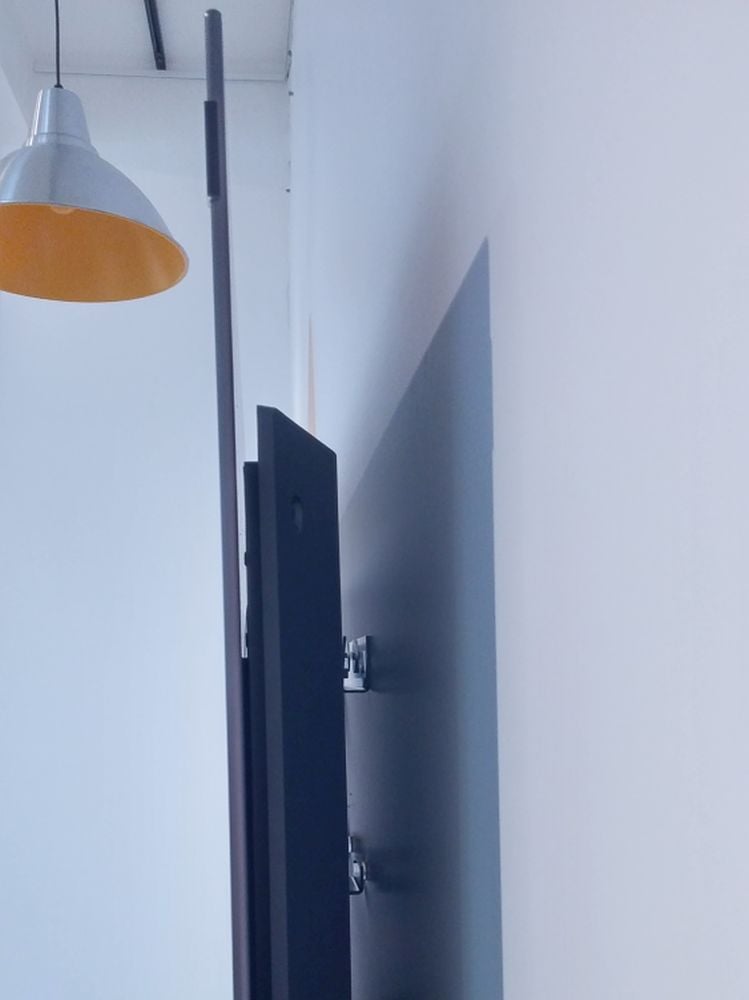 Koncepce televizoru Bild 7. Tenounký asi sedmi milimetrový panel obrazovky je motoricky posuvný na pevném základě, který je v tomto případě namontován na zeď.