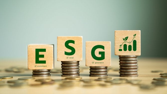 Koncepce ESG s dřevěnými bloky na zásobnících mincí představující environmentální, sociální a řídící principy pro udržitelné investice a odpovědnost firem