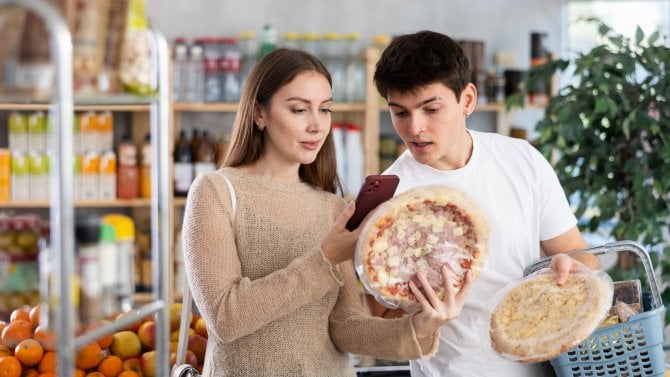 Pár mladý muž a mladá žena skenuje qr kód pro mraženou pizzu v obchodě