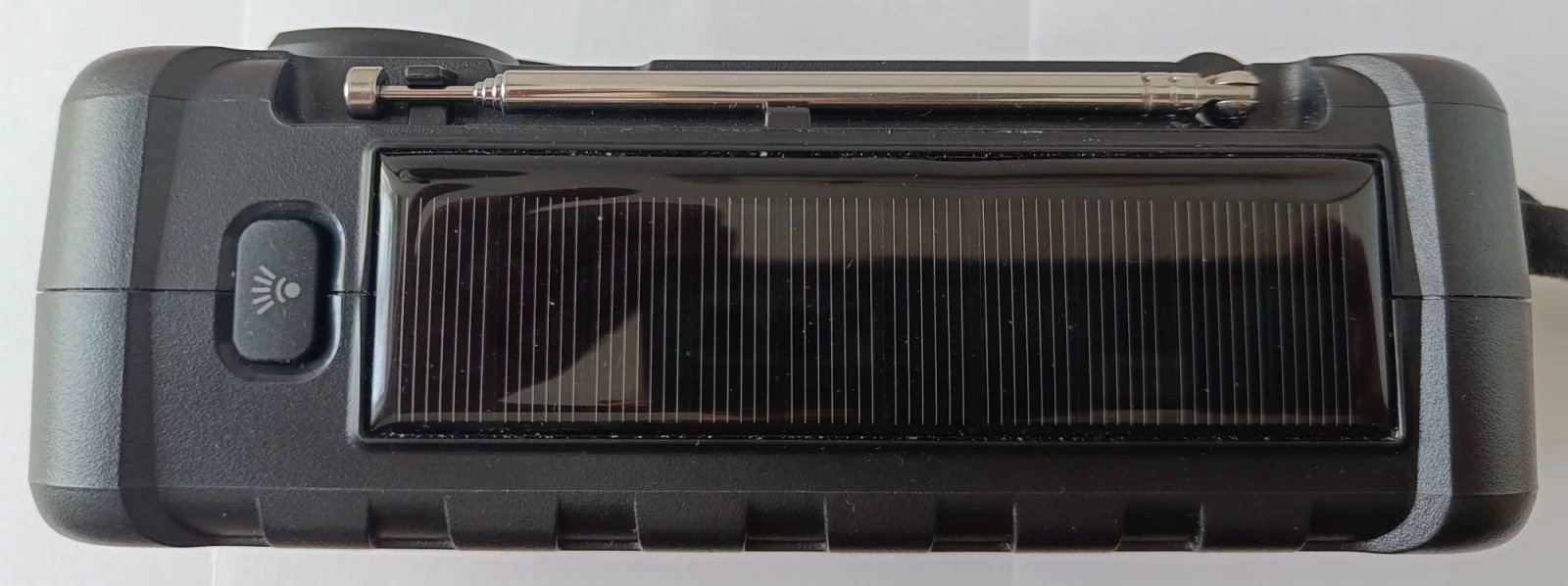 Horní část přístroje se solárním panelem a tlačítkem pro ovládání svítilny