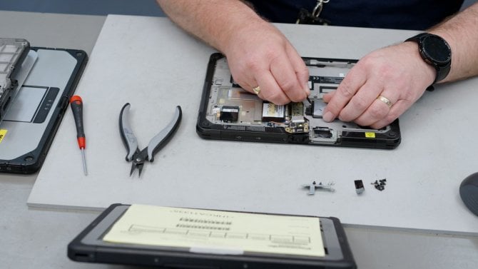 Panasonic Connect Europe servisní středisko v Cardiffu, muž opravuje počítač