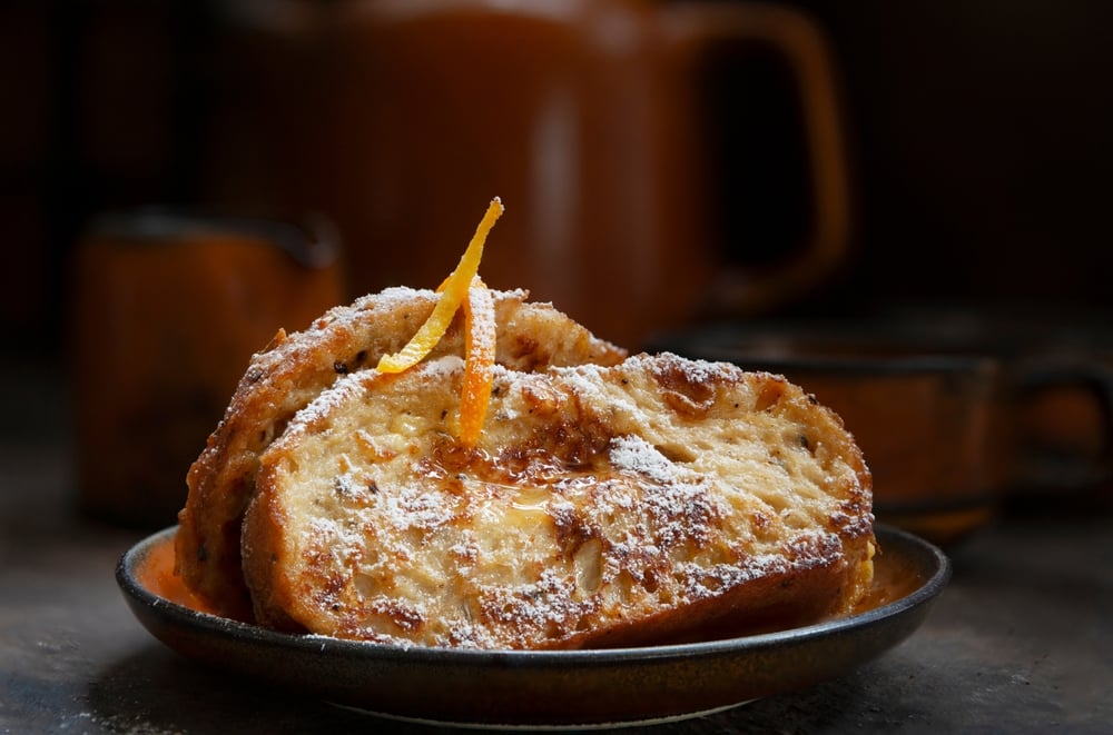 Dva kousky french toastu ozdobené pomerančovou kůrou