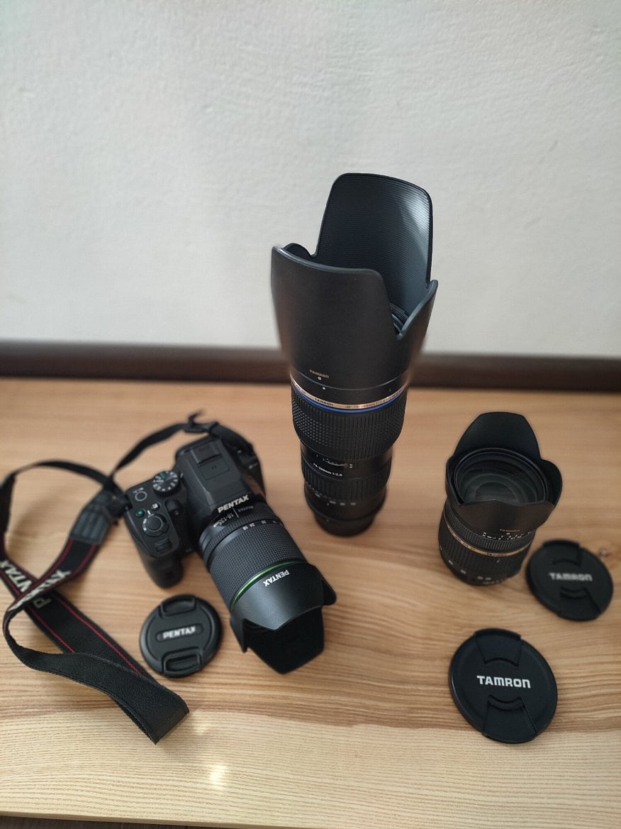 Digitální zrcadlovka Pentax K-S2 se „setovým“ objektivem Pentax SMC DA 18 – 135 mm f/3.5 – 5.6 ED AL (If) DC WR s nasazenou sluneční clonou a dále objektiv Tamron AF SP 70-200mm f/2,8 Di LD IF Macro a úplně vpravo je TAMRON 28-75 mm f/2,8 SP XR Di Asph.