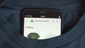 Mobilní telefon s postmarketOS trčí z trička