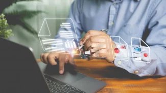 Podnikatel podepisuje perem schválený elektronický podpis na elektronickém dokumentu pomocí notebooku na dřevěném stole. Správa dokumentů, nápady na bezpapírovou kancelář