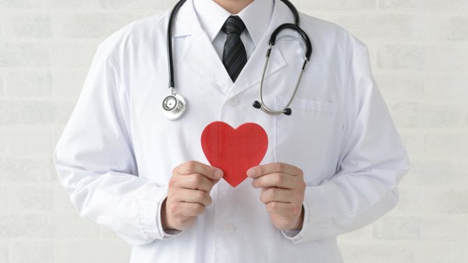 Lékař drží symbolické červené srdce