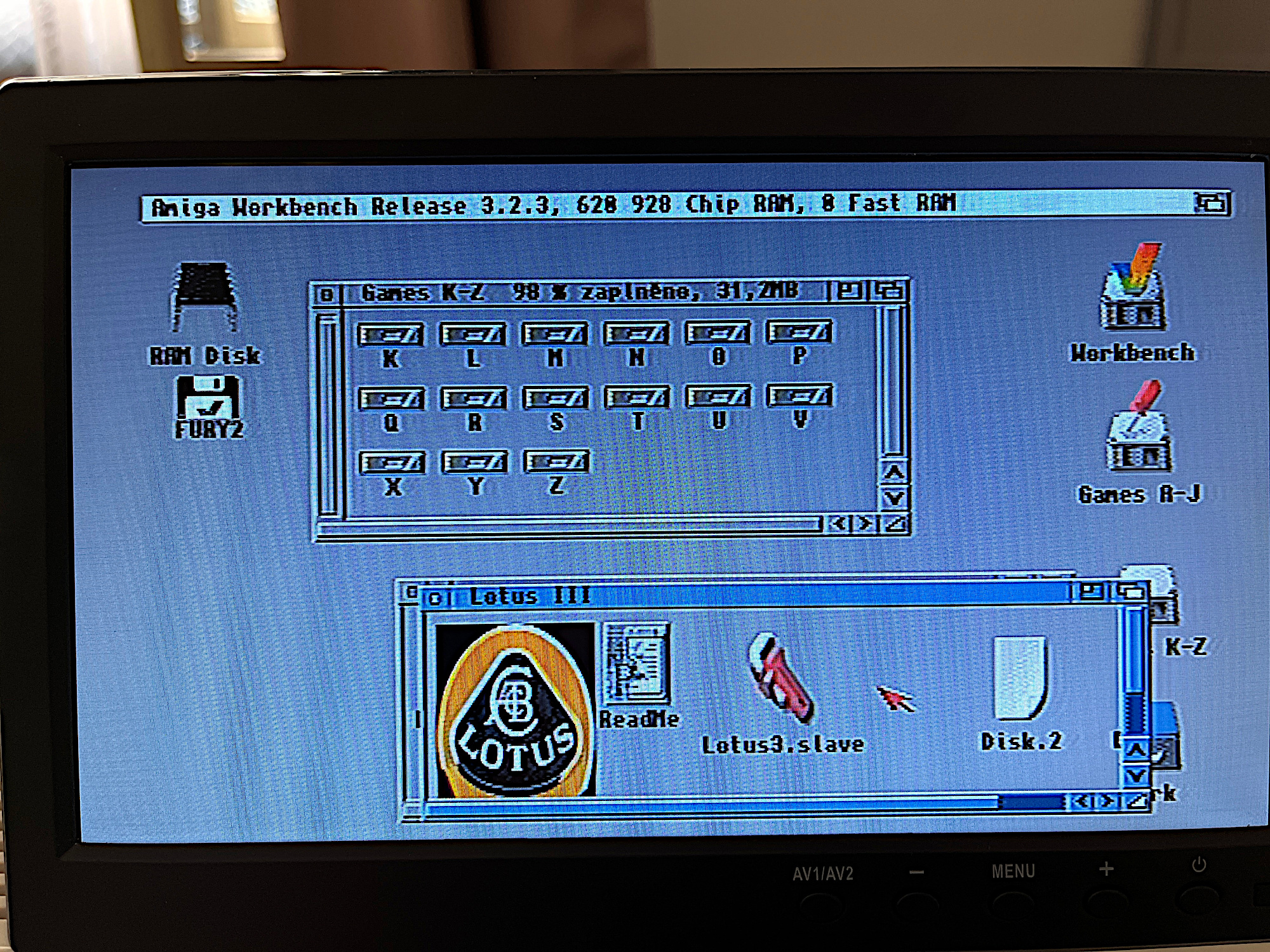 A již běžící AmigaOS 3.2, ofoceno z obrazovky. Složka (je vytvořena jako samostatný disk) s WHDLoad hrami, a otevřen šuplík s Lotusem III.
