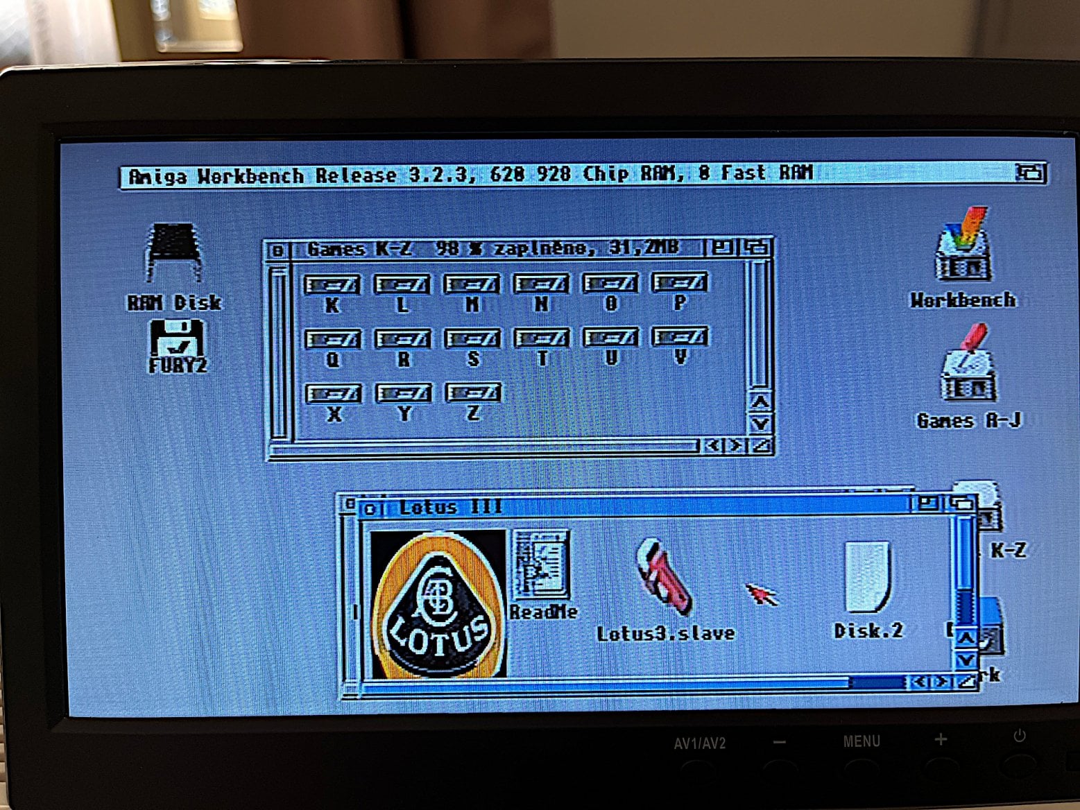 A již běžící AmigaOS 3.2, ofoceno z obrazovky. Složka (je vytvořena jako samostatný disk) s WHDLoad hrami, a otevřen šuplík s Lotusem III.