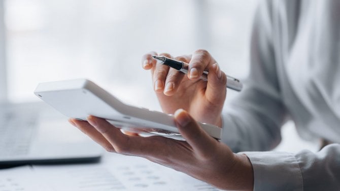 Počítání na kalkulačce. Ruce ženy v kanceláři