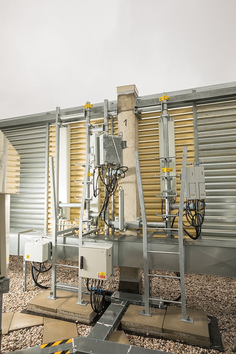 Antény jsou schované za vyměněnými žaluziemi, které tvoří architektonický prvek budovy. Z ulice není kamufláž vůbec patrná.