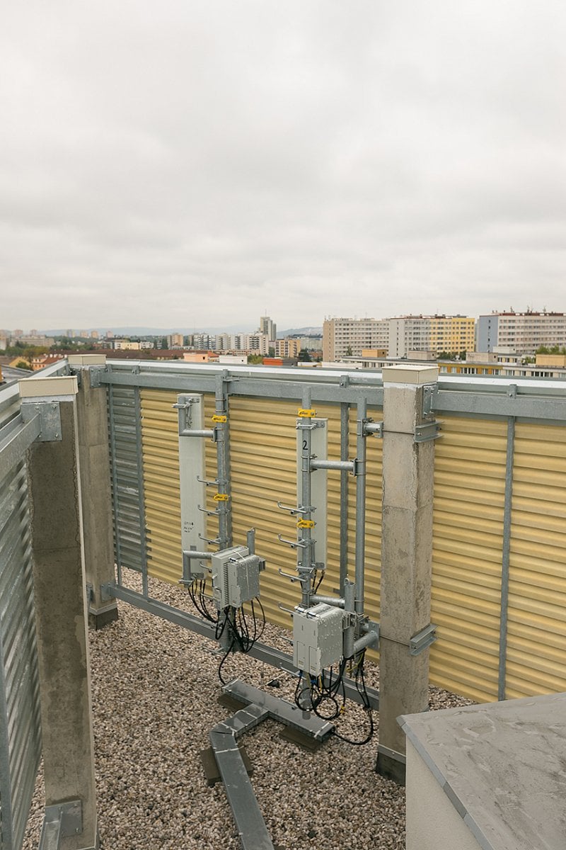 Antény jsou schované za vyměněnými žaluziemi, které tvoří architektonický prvek budovy. Z ulice není kamufláž vůbec patrná.
