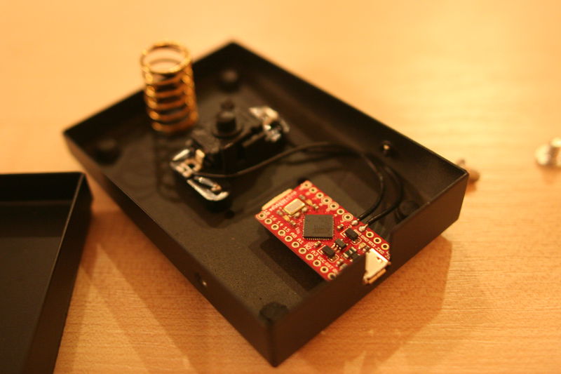 ... a už vyskočí obsah. Pružina, tlačítko a miniaturní deska Arduino.