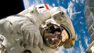 Astronaut Piers Sellers během třetího výstupu do kosmu v rámci mise STS-121, při kterém předvádí techniky opravy tepelného štítu.