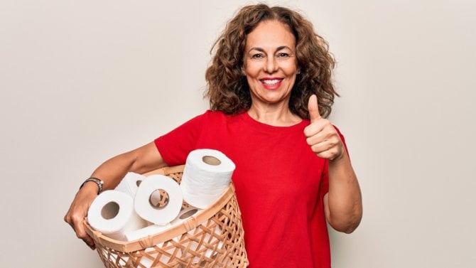 Žena má v košíku zásobu toaletního papíru a dává palec nahoru