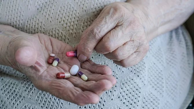 Ruce seniora s několika různými tabletami