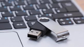 Flash disk ležící u klávesnice na notebooku