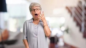 Starší žena v šoku s otevřenými ústy, s rukou před sebou