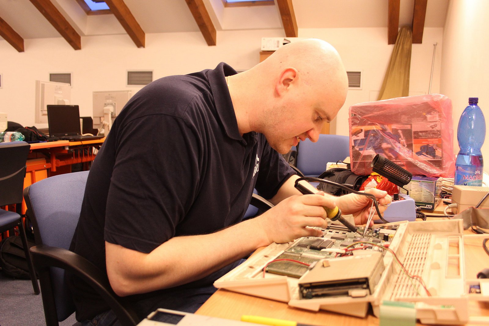 Jaromír „Ťavvva“ Cápík pájí IDE kabel do Amigy 1200 - hardware hacking je na Atariádách běžnou součástí neplánovaného programu.