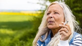 Starší žena kouří cigaretu