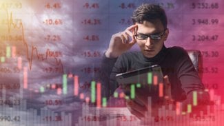 Frustrovaný investor. Muž s tabletem u červených kurzů akcií. Smutný investor sedí u stolu. Mladý investor sleduje, jak klesají ceny akcií. Obchodník a klesající grafy. Bankrot, krize