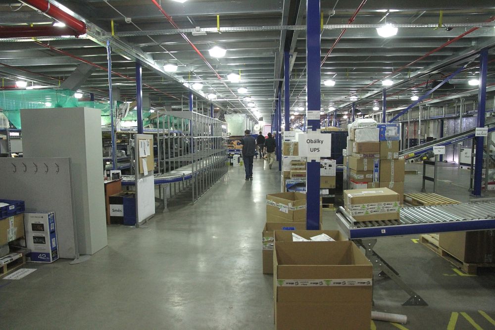 Vstupujeme do centrálního skladu internetového obchodu Alza.cz v pražských Horních Počernicích. Začátkem prosince expeduje denně mezi 20 a 23 tisíci zásilek. 