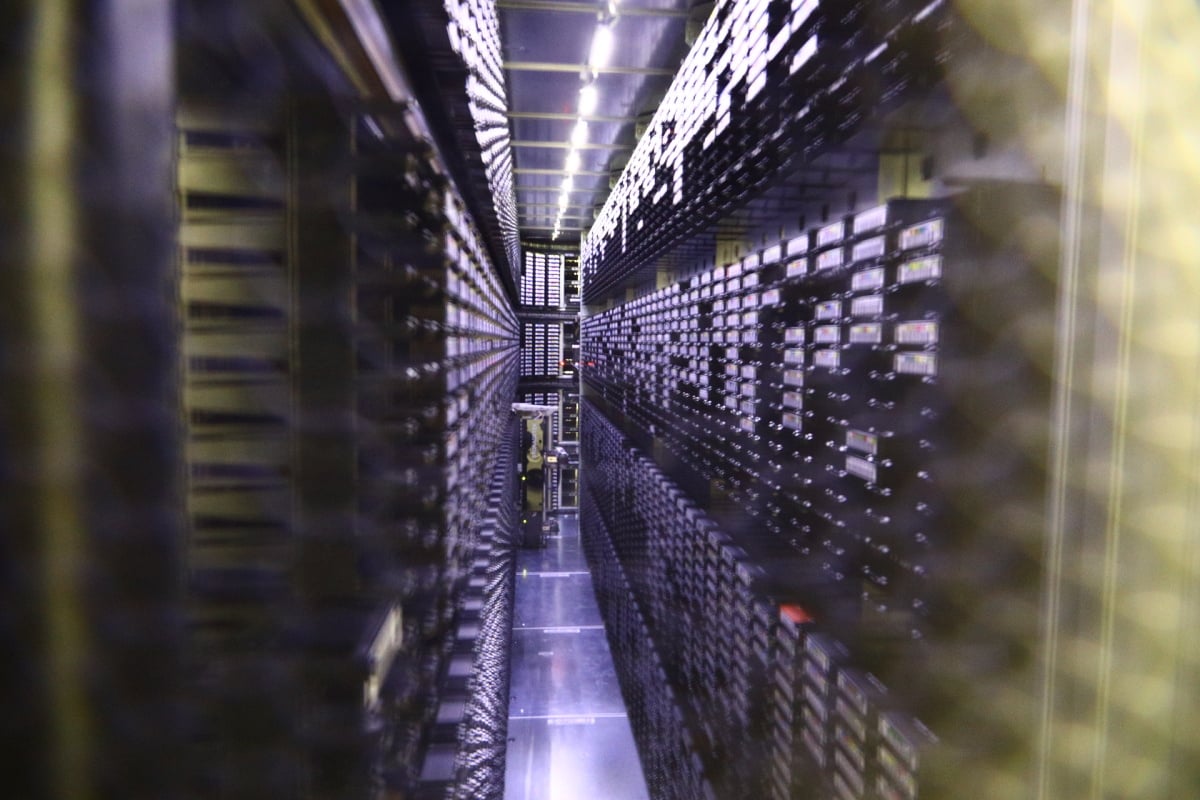 O ukládání a vybírání pásků se starají malí roboti, kteří jezdí na kolejnicích uvnitř knihovny.