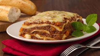 Talíř s porcí boloňských lasagní a čerstvou bazalkou