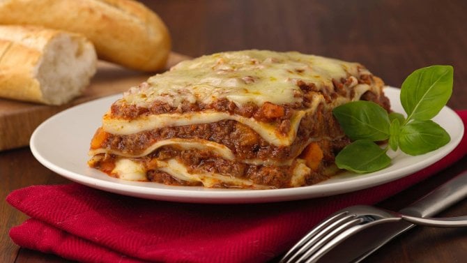 Talíř s porcí boloňských lasagní a čerstvou bazalkou