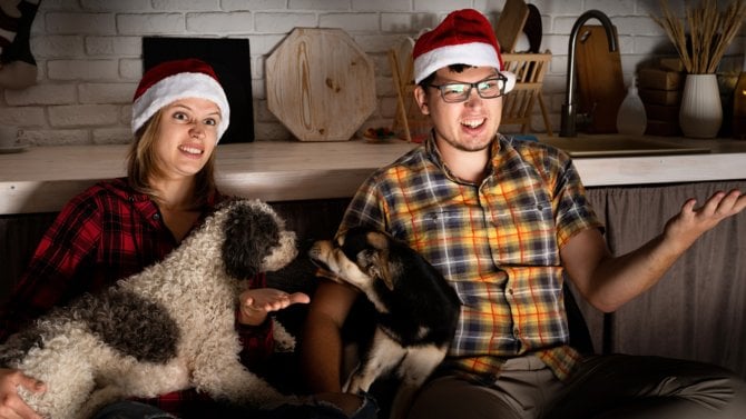 Mladí lidé ve vánočním sledují televizi s emocemi