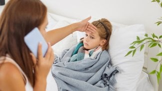 Máma kontroluje malé dceři horké čelo