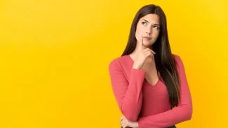 Mladá dívka se zamýšlí. U toho hledí vzhůru a přikládá prst k ústům