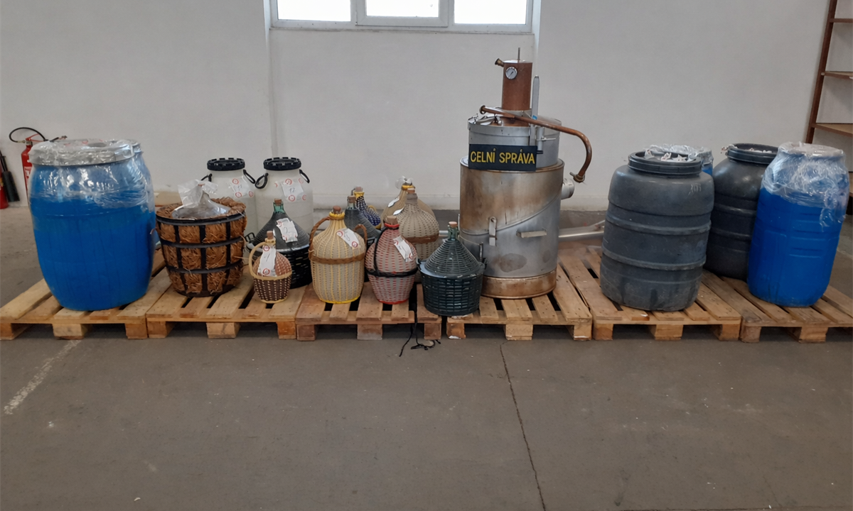 Na obrázku jsou vyobrazeny demižony postavené v místnosti