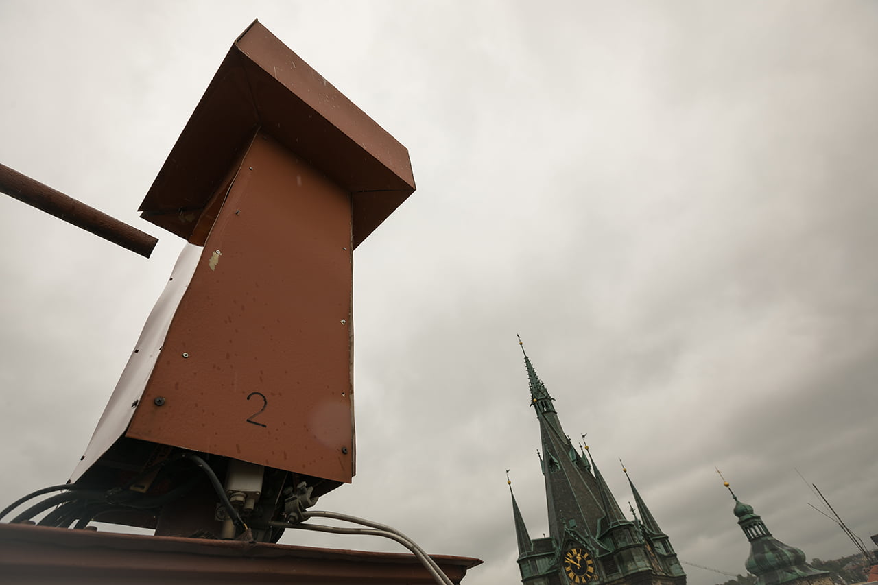 Antény jsou schované v červeném kříži na střeše budovy. Senovážné náměstí, Praha.